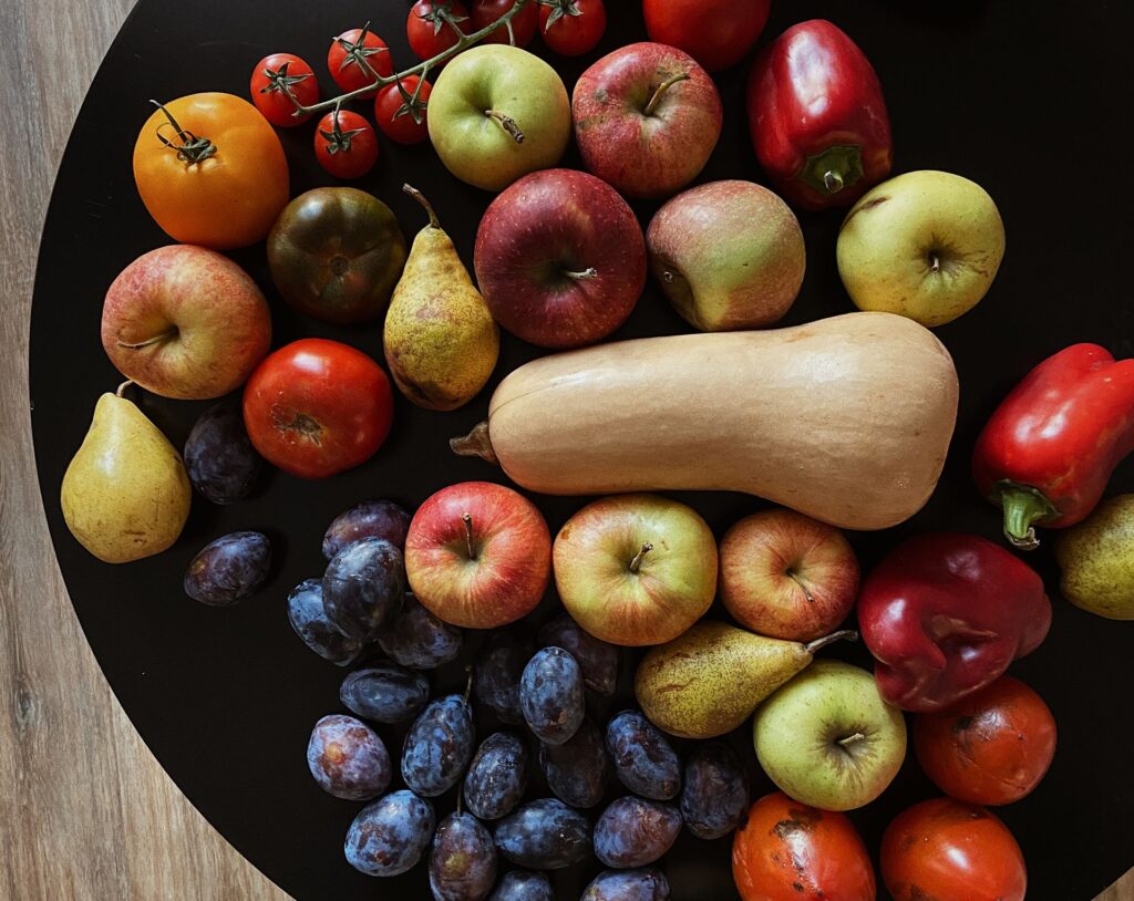 A vibrant mix of fresh fruits and vegetables displayed on a round table for healthy eating inspiration.