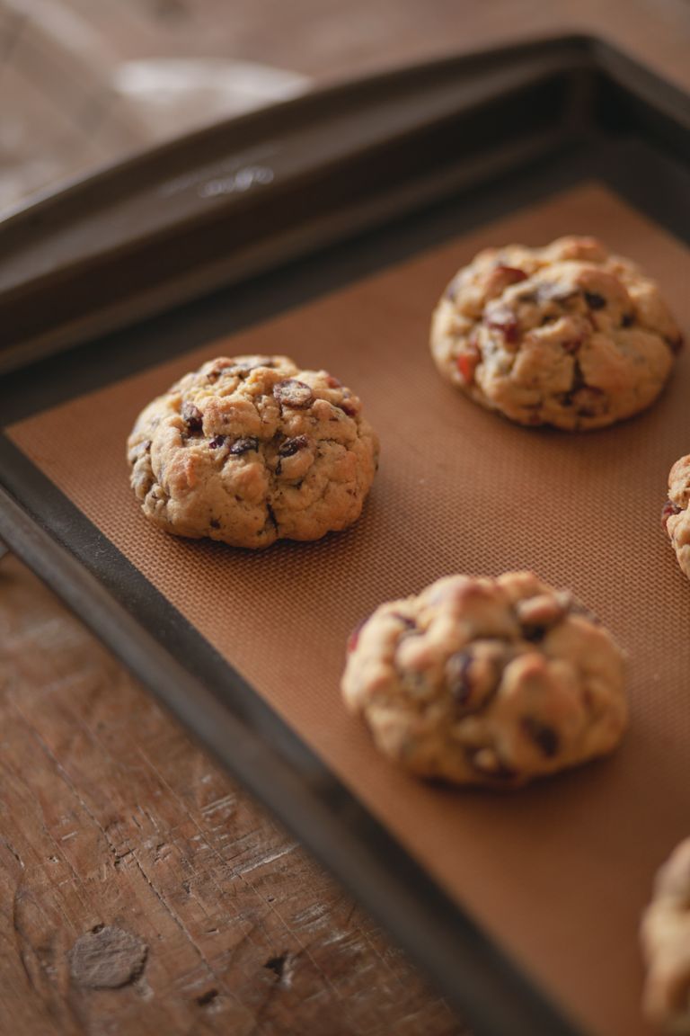 Close-up view of freshly baked chocolate chip cookies resting on a baking tray.