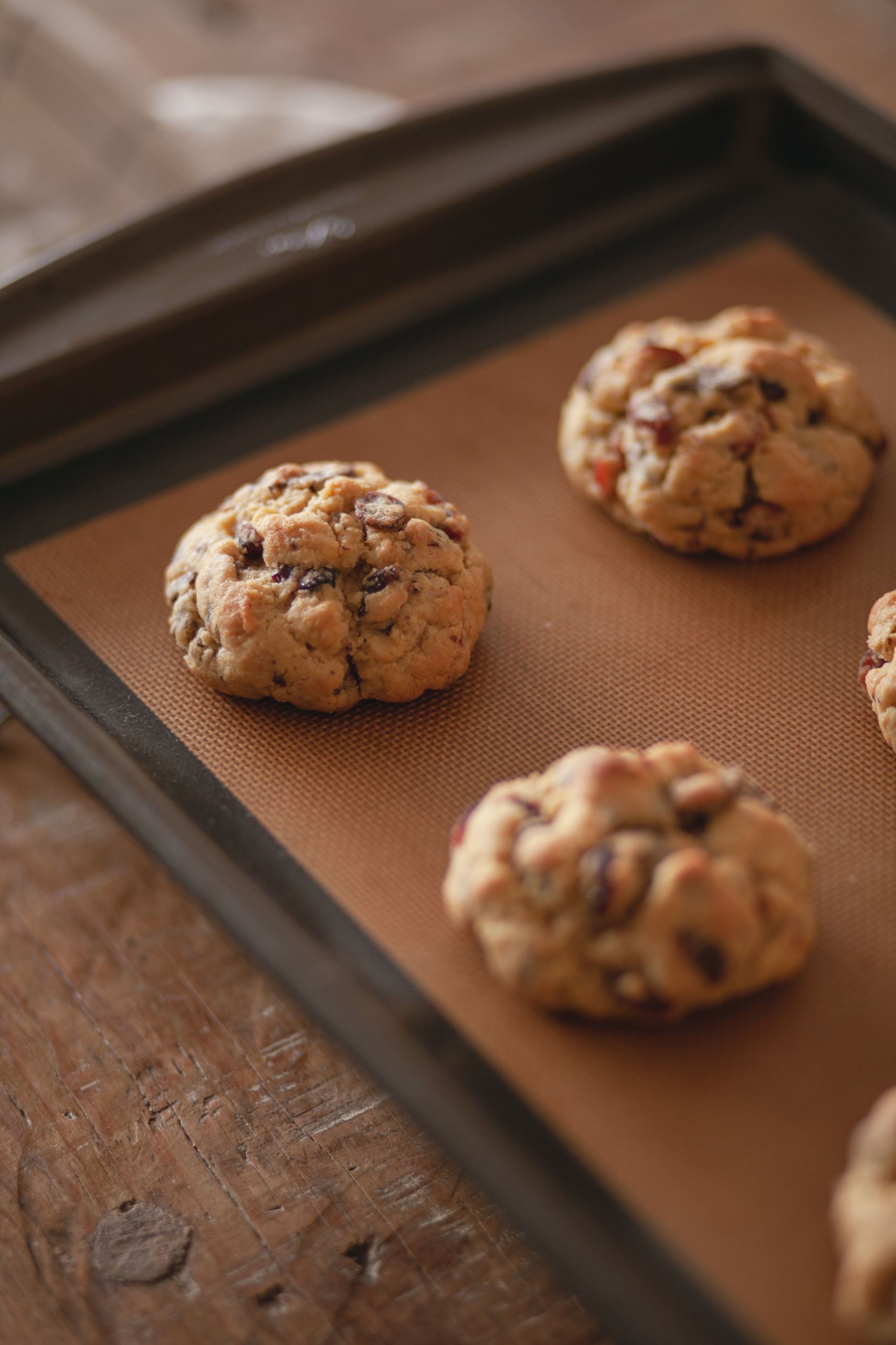 Close-up view of freshly baked chocolate chip cookies resting on a baking tray.