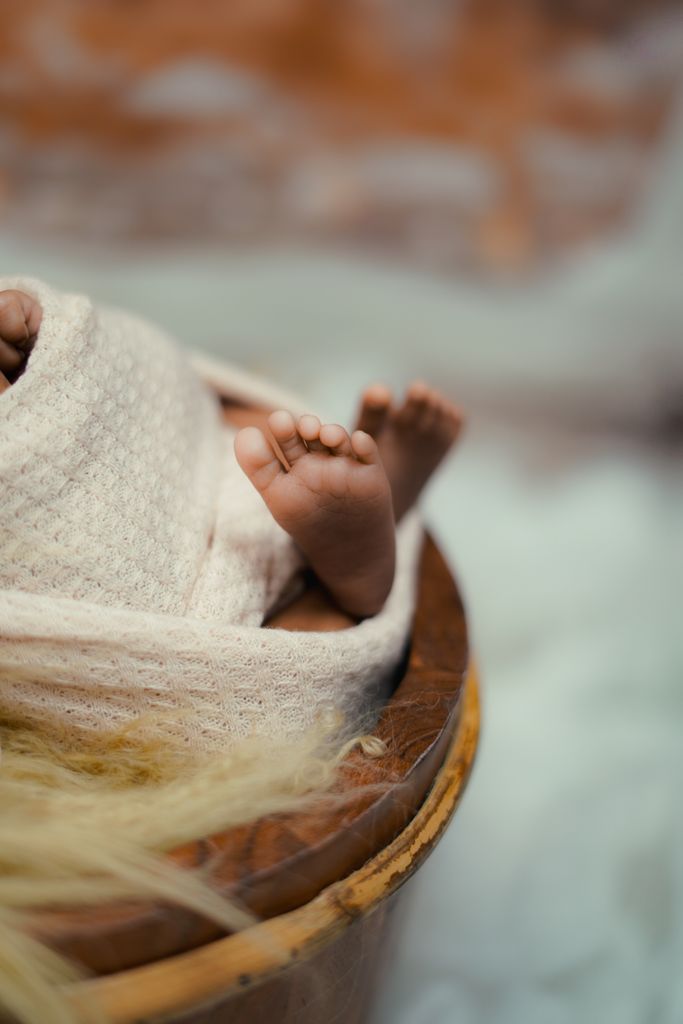 Adorable newborn baby feet wrapped in a soft, cozy blanket, symbolizing warmth and care.